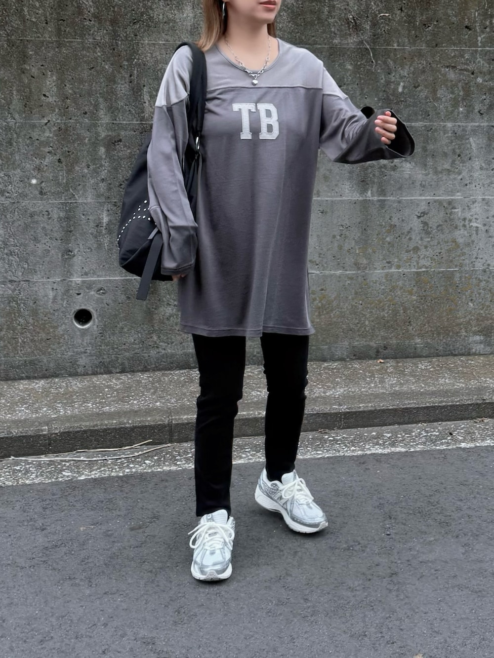 ブラック系のボストンバッグ、シルバー系のスニーカー、グレー系のTシャツ/カットソーを着用したレディースの秋コーディネートの3枚目の写真