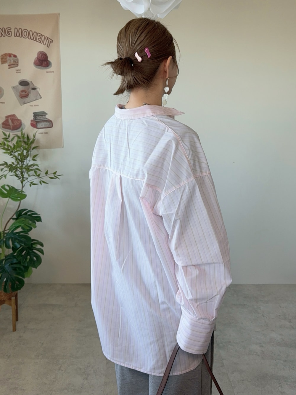 ピンク系のシャツ/ブラウス、グレー系のスウェットパンツ、ブラウン系のハンドバッグを着用したレディースの春コーディネートの3枚目の写真