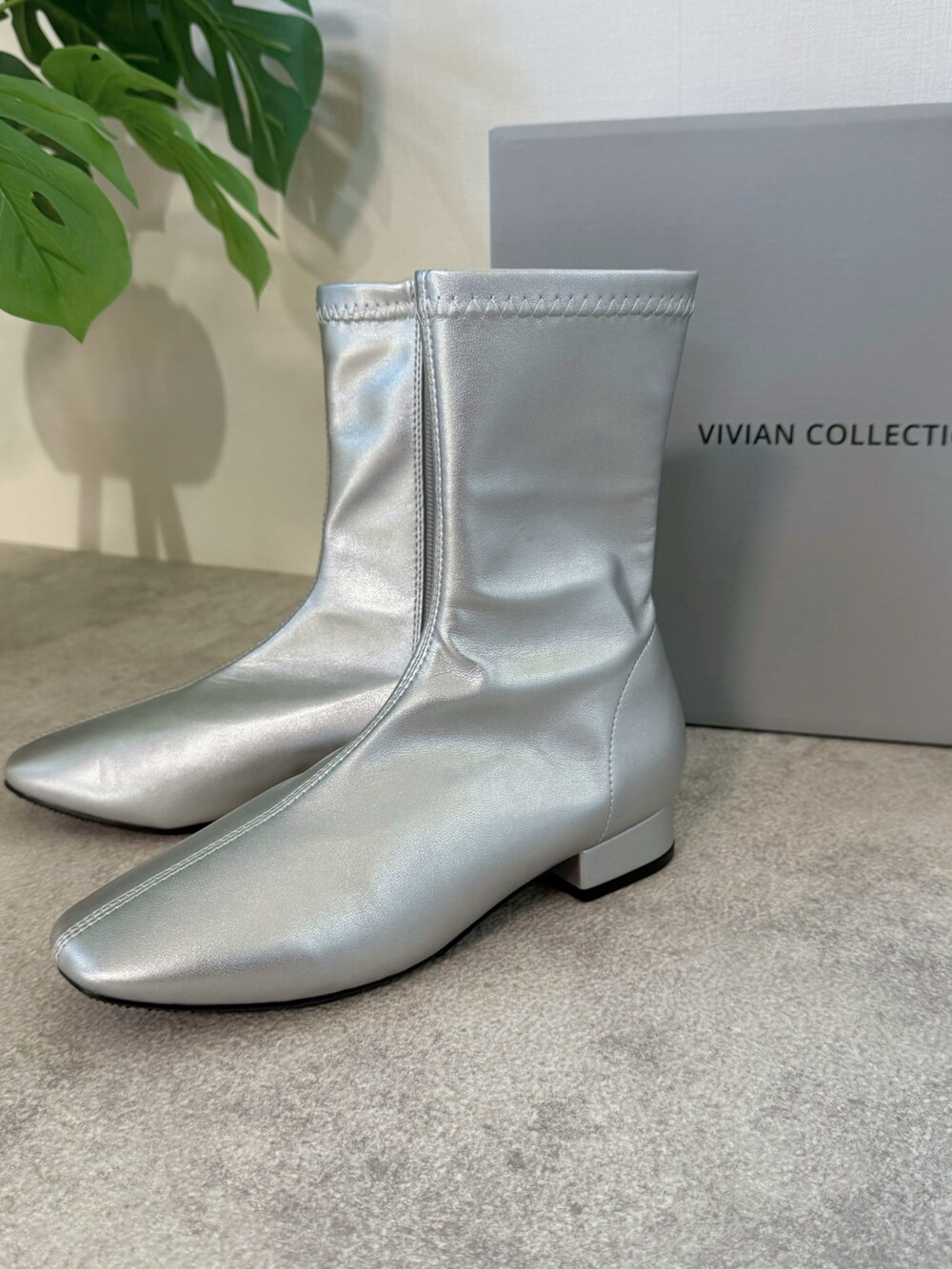 グレー系のスカート、グレー系のスウェット、シルバー系のブーツを着用したレディースの冬コーディネートの5枚目の写真