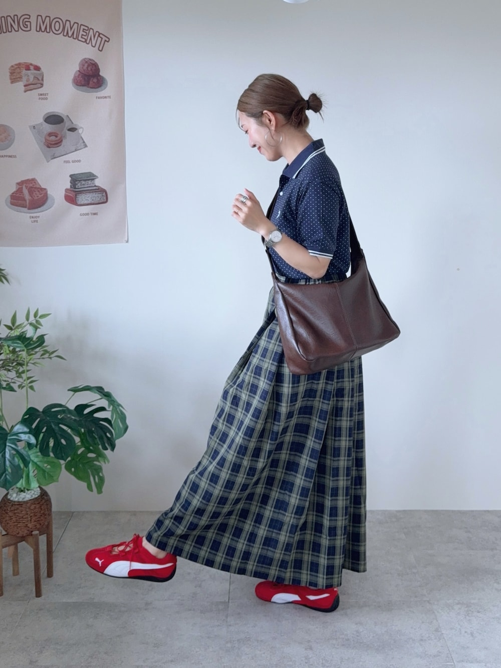 その他のポロシャツ、グリーン系のスカート、ブラウン系のショルダーバッグを着用したレディースの夏コーディネートの2枚目の写真