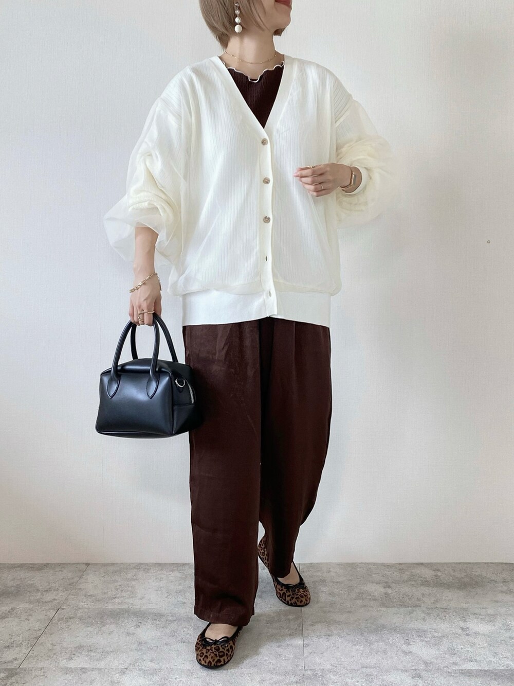 ホワイト系のカーディガン/ボレロ、ブラウン系のその他パンツ、ブラウン系のバレエシューズを着用したレディースの秋コーディネートの2枚目の写真