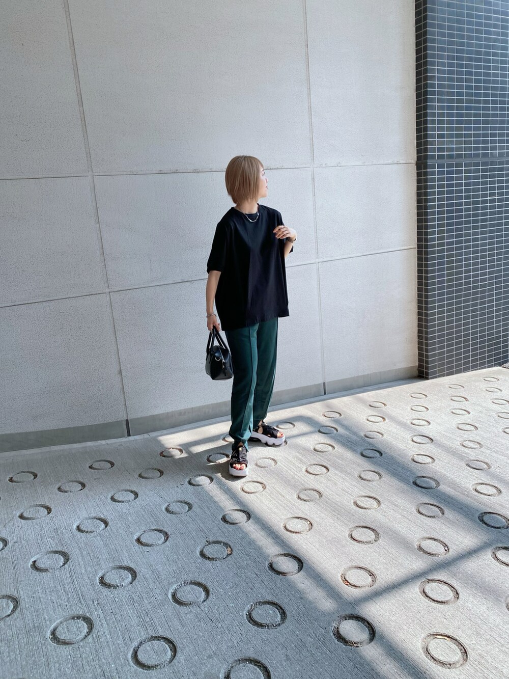 グリーン系のスウェットパンツ、ブラック系のTシャツ/カットソー、ブラック系のバッグを着用したレディースの夏コーディネートの3枚目の写真