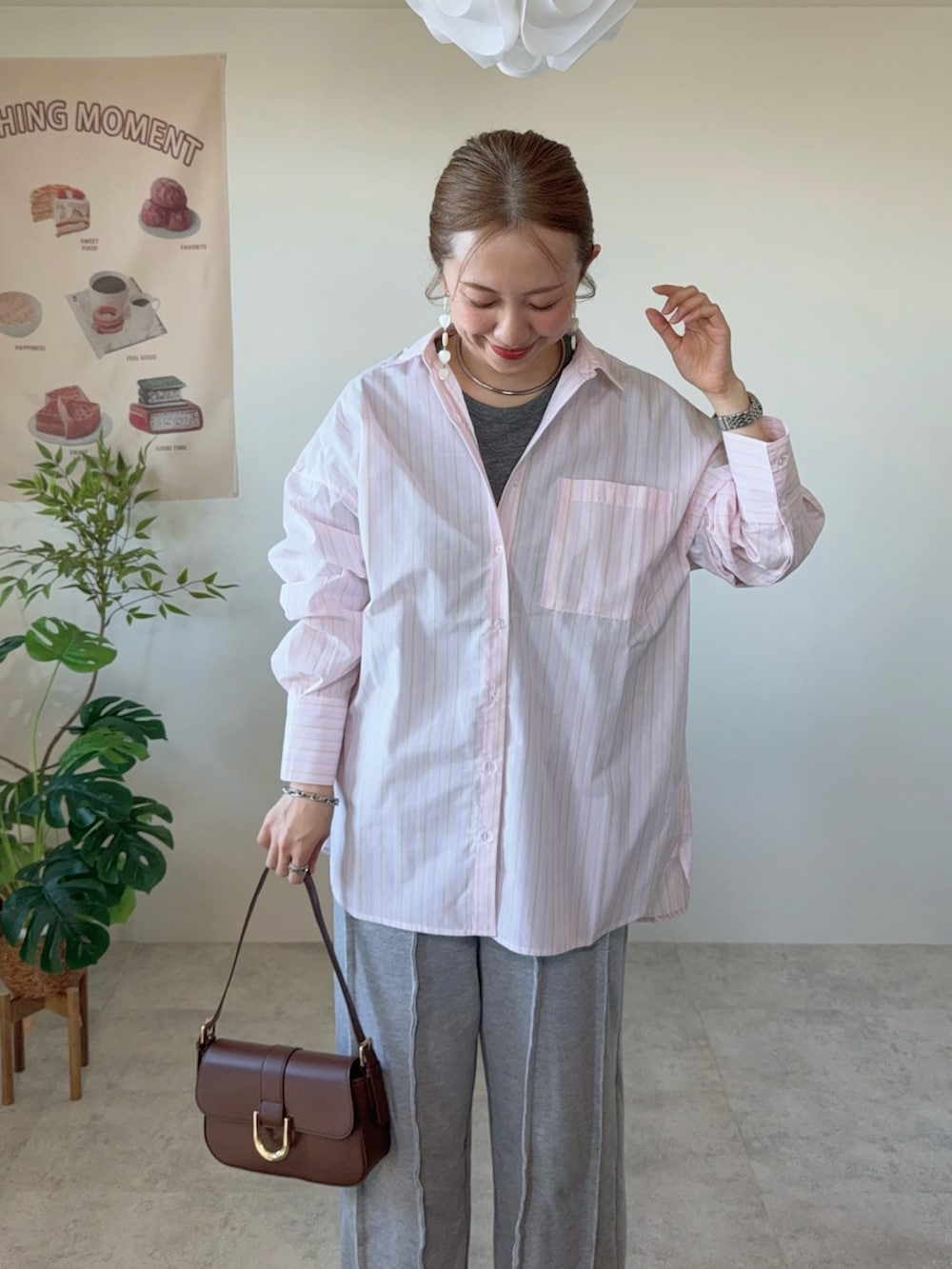 ピンク系のシャツ/ブラウス、グレー系のスウェットパンツ、ブラウン系のハンドバッグを着用したレディースの春コーディネートの2枚目の写真