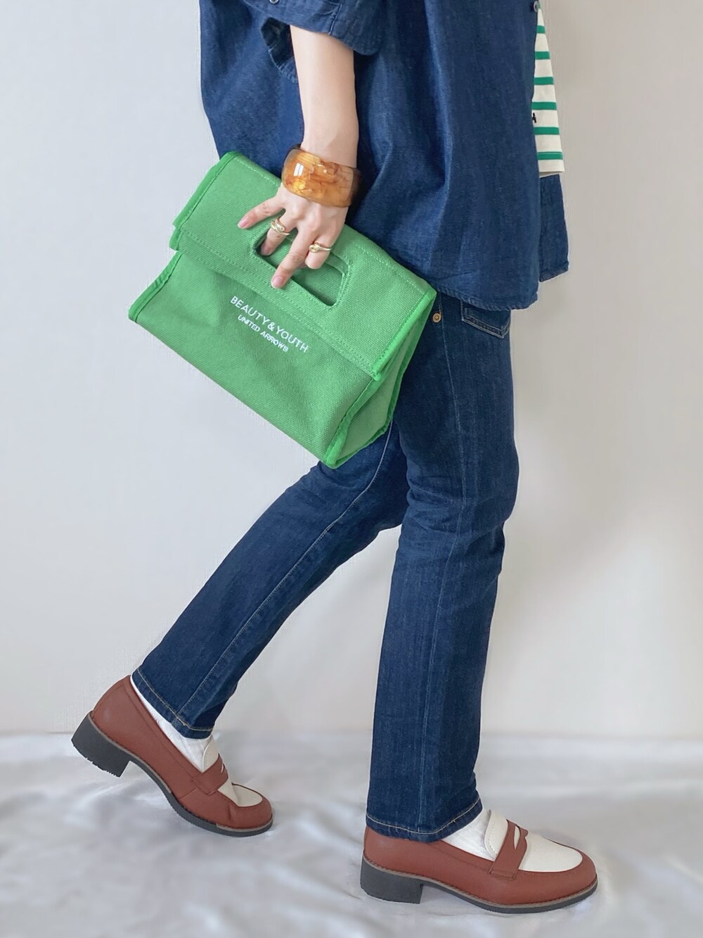 ブルー系のシャツ/ブラウス、グリーン系のTシャツ/カットソー、グリーン系のトートバッグを着用したレディースの春コーディネートの4枚目の写真