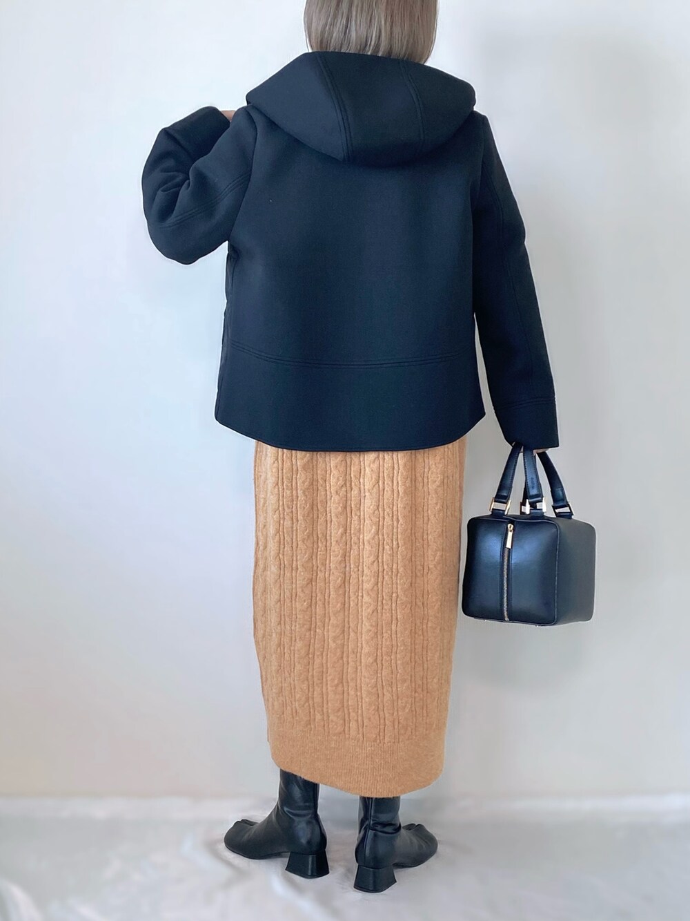 ブラック系のブルゾン、オレンジ系のワンピース、ブラック系のハンドバッグを着用したレディースの秋コーディネートの2枚目の写真