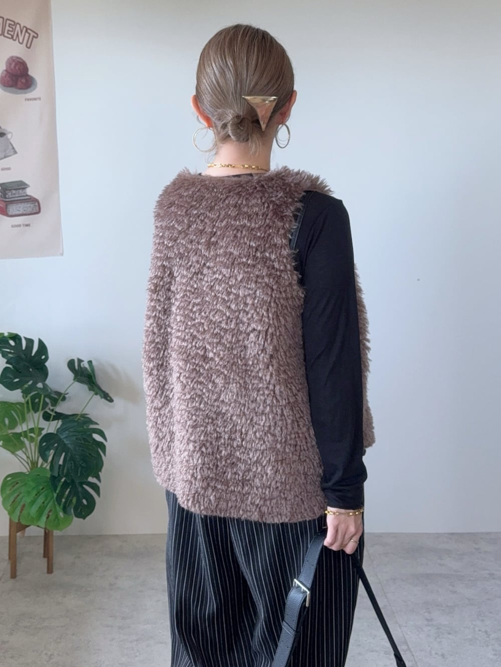 ブラック系のショルダーバッグ、ブラウン系のベスト、ブラック系のその他パンツを着用したレディースの秋コーディネートの5枚目の写真