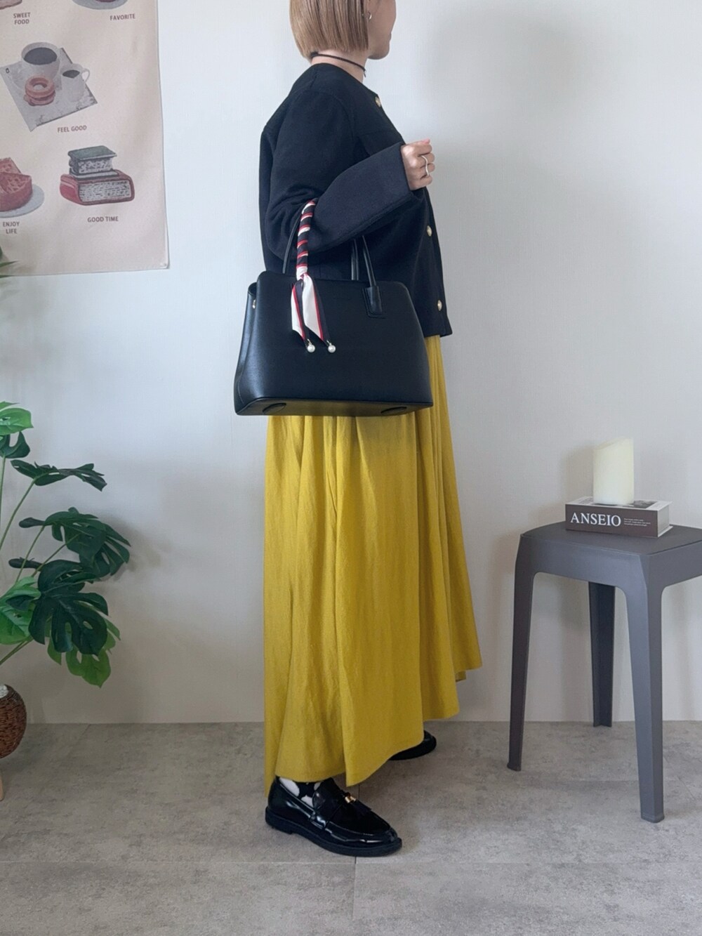 ブラック系のジャケット/アウター、ブラック系のハンドバッグ、イエロー系のワンピースを着用したレディースの冬コーディネートの5枚目の写真