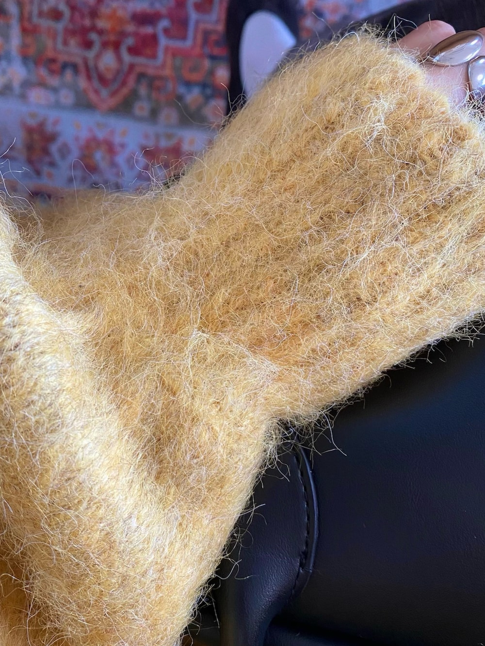 イエロー系のカーディガン/ボレロ、ブラック系のバッグ、グレー系のデニムパンツを着用したレディースの冬コーディネートの5枚目の写真