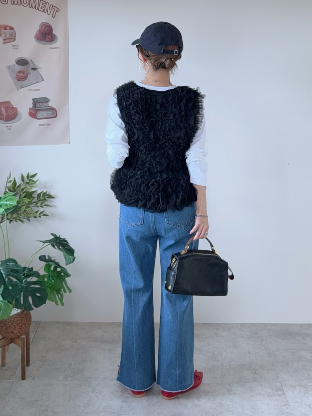 ブラック系のベスト、ブルー系のデニムパンツ、レッド系のバレエシューズを着用したレディースの秋コーディネートの4枚目の写真