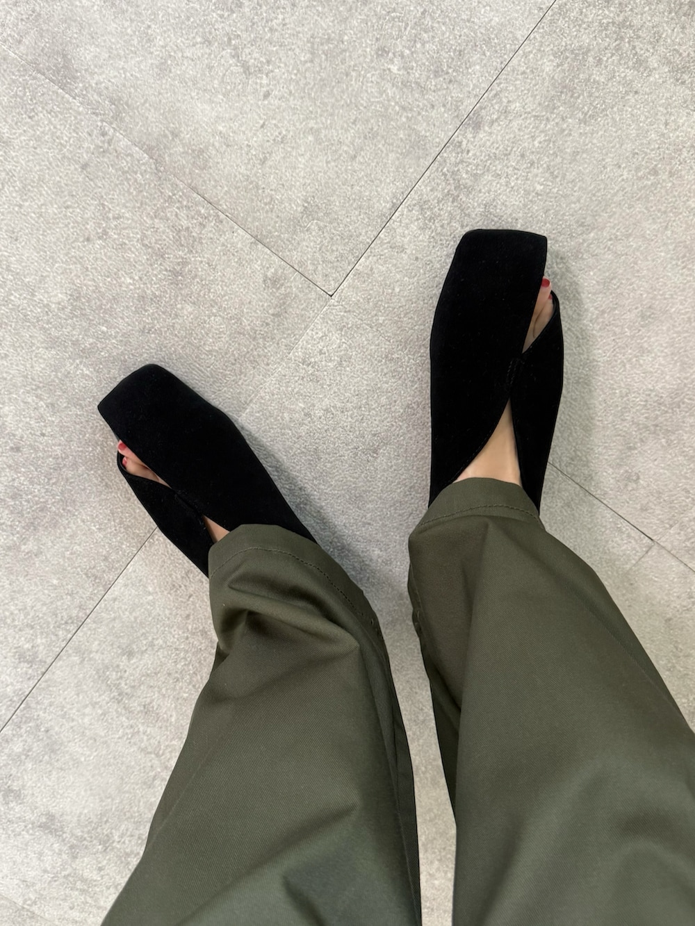 グリーン系のチノパンツ、ブラック系のパンプス、ブラック系のカーディガン/ボレロを着用したレディースの秋コーディネートの5枚目の写真