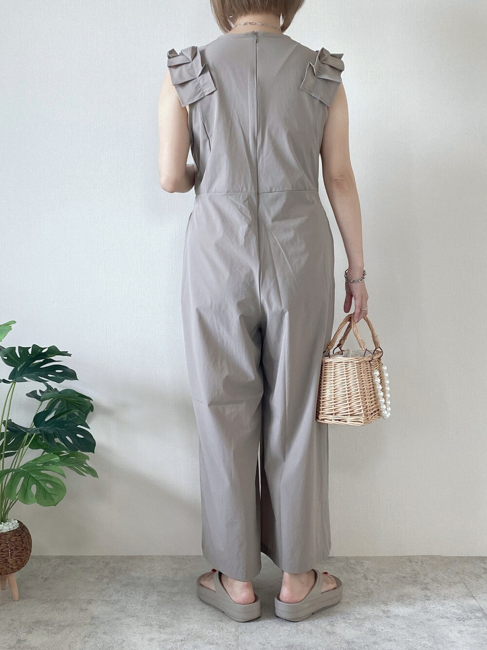 ベージュ系のかごバッグ、ベージュ系のサンダル、ベージュ系のラッシュガードを着用したレディースの夏コーディネートの4枚目の写真