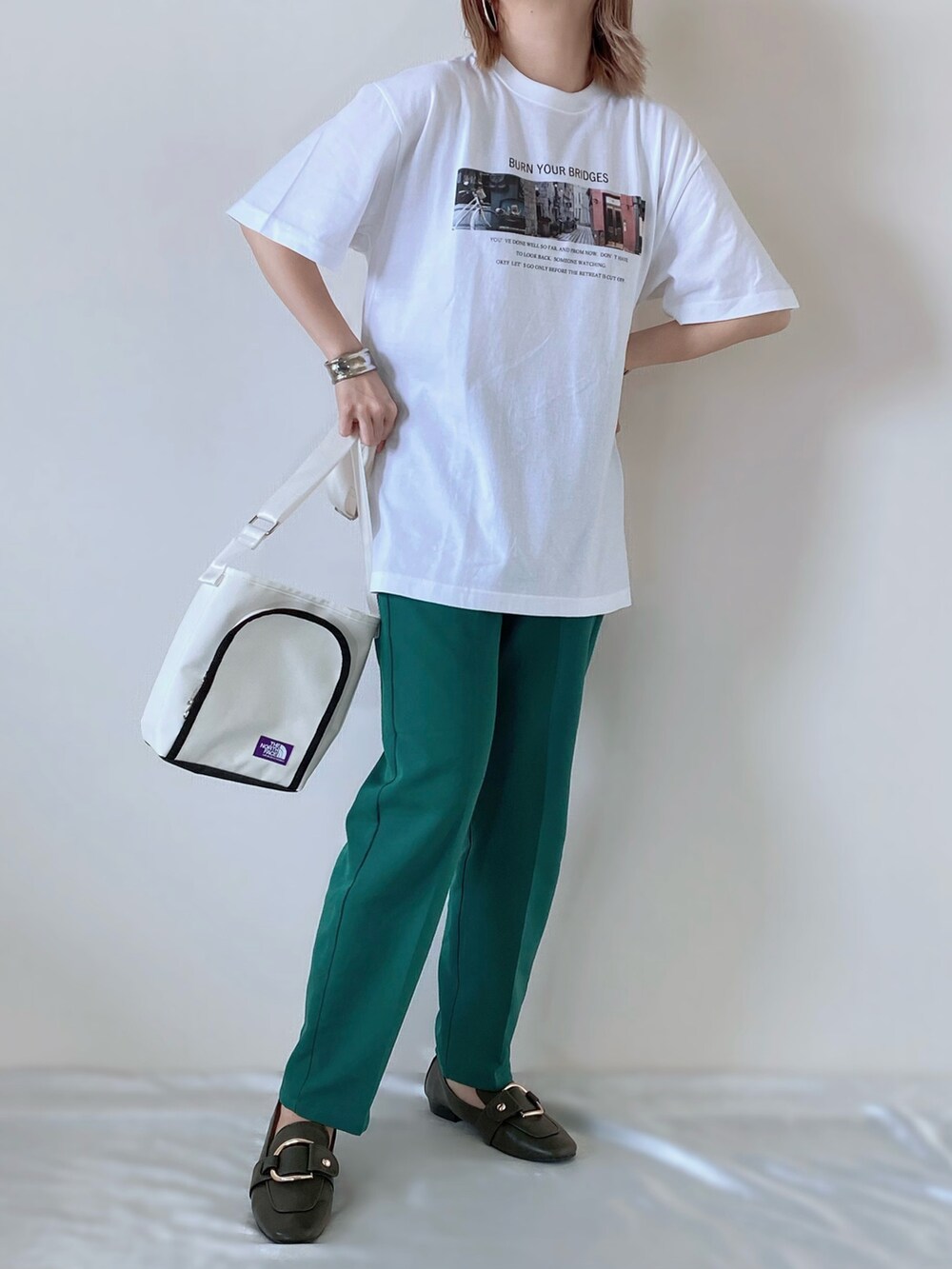 ホワイト系のTシャツ/カットソー、グリーン系のスラックス、グリーン系のローファーを着用したレディースの春コーディネートの2枚目の写真