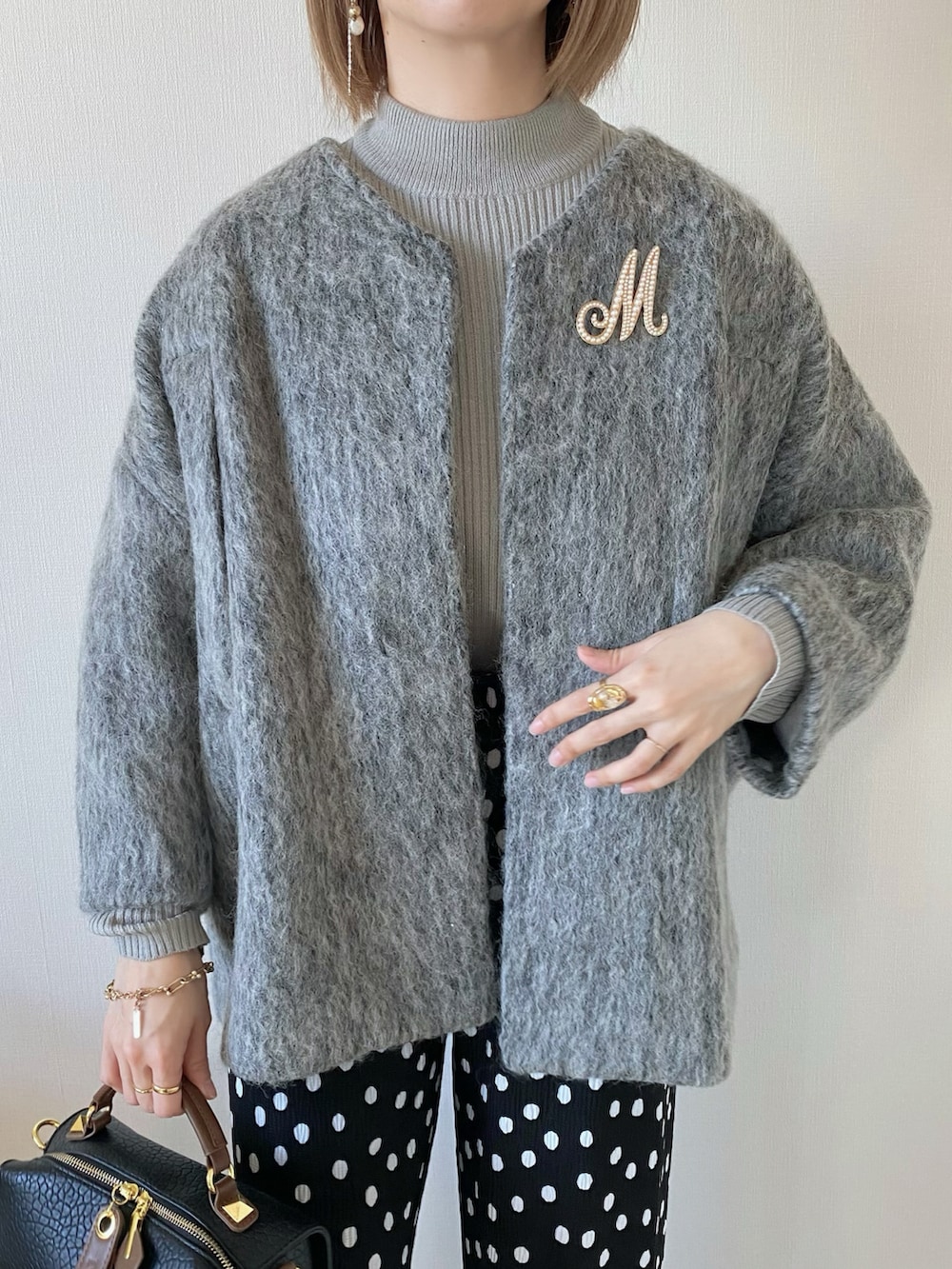 グレー系のダウンジャケット/コート、ブラック系のその他パンツ、ブラック系のパンプスを着用したレディースの冬コーディネートの5枚目の写真