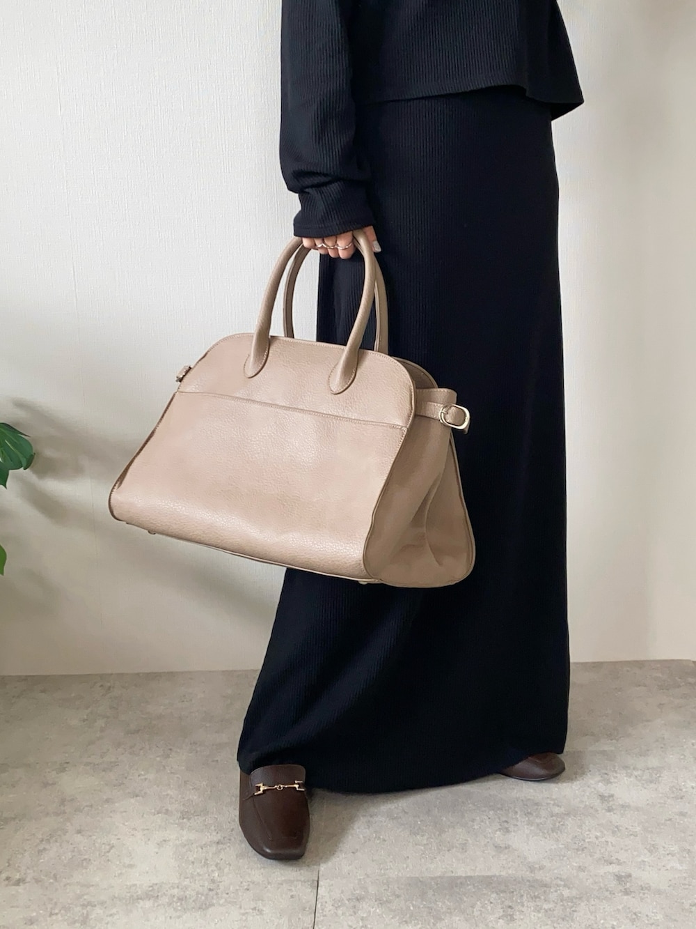 ブラック系のワンピース、ベージュ系のボストンバッグ、ブラウン系のローファーを着用したレディースの秋コーディネートの4枚目の写真