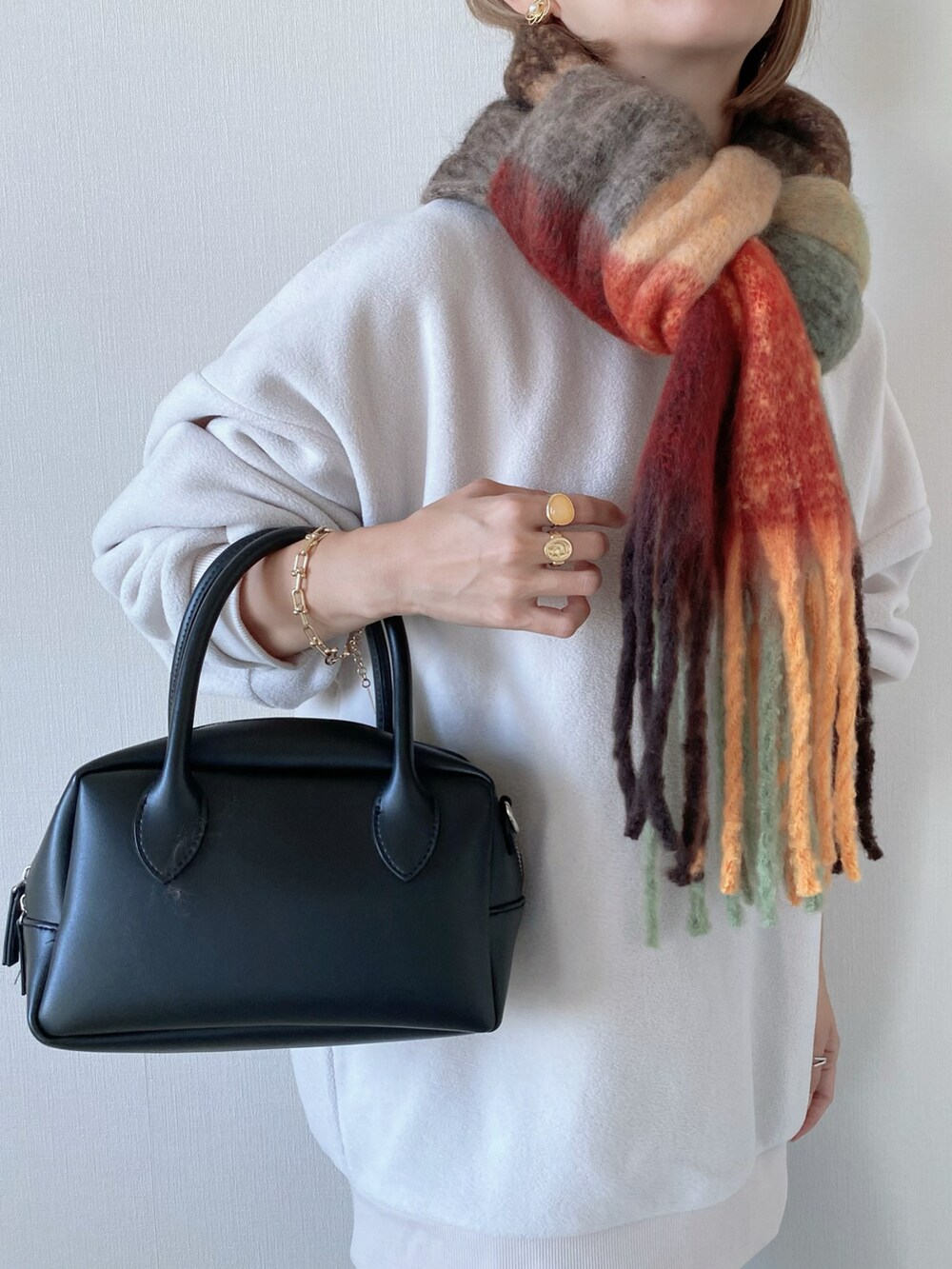 ホワイト系のスウェット、ホワイト系のスニーカー、ブラック系のバッグを着用したレディースの冬コーディネートの5枚目の写真