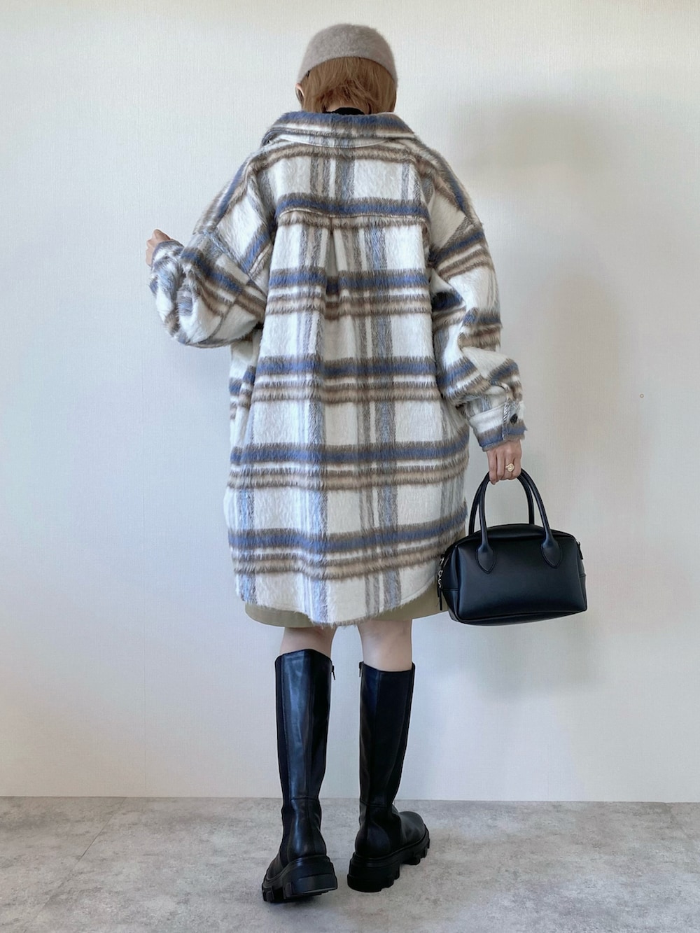 ホワイト系のブルゾン、ブラック系のニット/セーター、ブラック系のバッグを着用したレディースの秋コーディネートの5枚目の写真