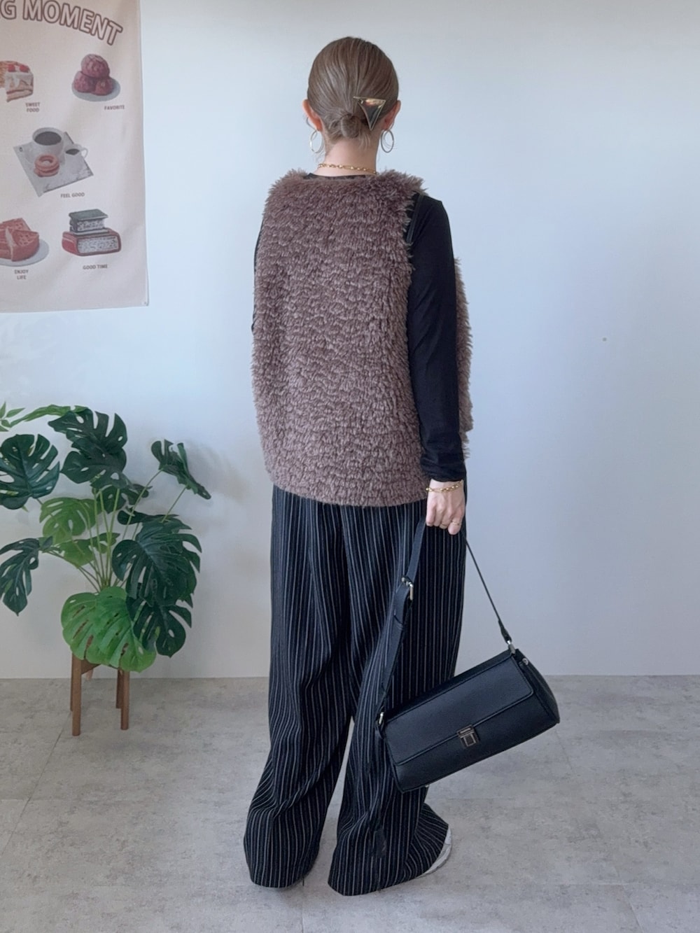 ブラック系のショルダーバッグ、ブラウン系のベスト、ブラック系のその他パンツを着用したレディースの秋コーディネートの2枚目の写真