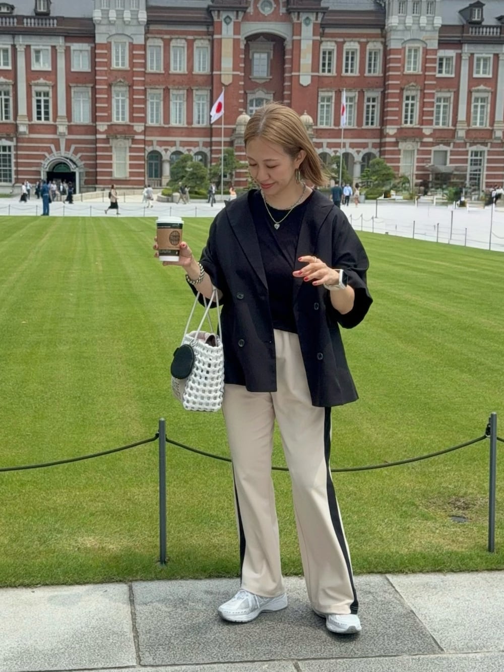 ホワイト系のスニーカー、ホワイト系のかごバッグ、ブラック系のジャケット/アウターを着用したレディースの夏コーディネートの2枚目の写真