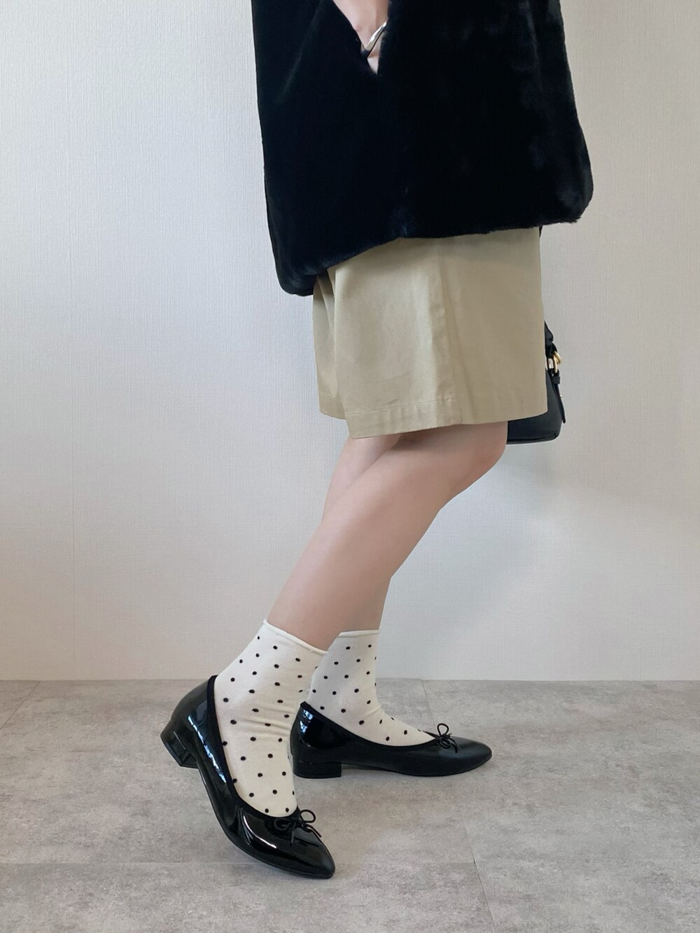 ブラック系のニット/セーター、ブラック系のバッグ、ブラック系のパンプスを着用したレディースの秋コーディネートの5枚目の写真