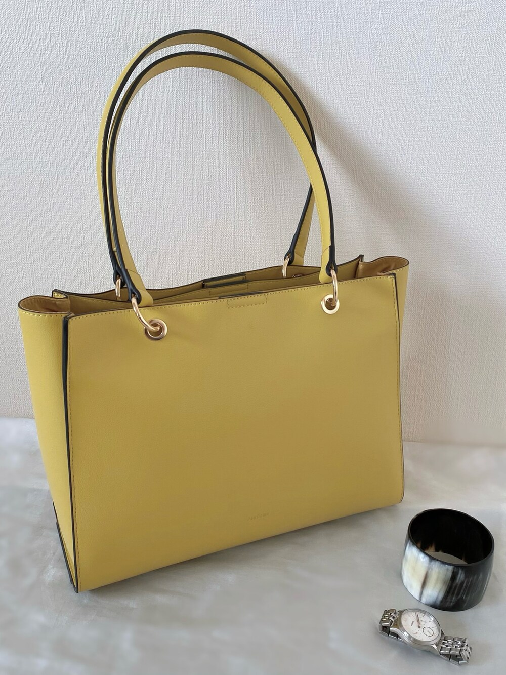 イエロー系のトートバッグ、ホワイト系のトップス、シルバー系のサンダルを着用したレディースの夏コーディネートの5枚目の写真