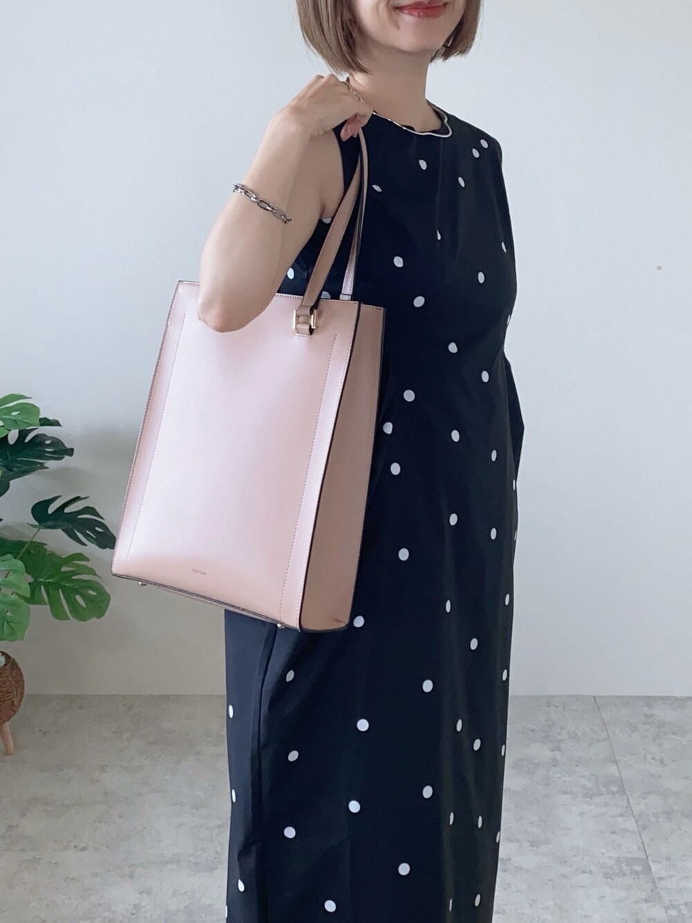 ブラック系のサンダル、ブラック系のワンピース、ピンク系のトートバッグを着用したレディースの夏コーディネートの2枚目の写真