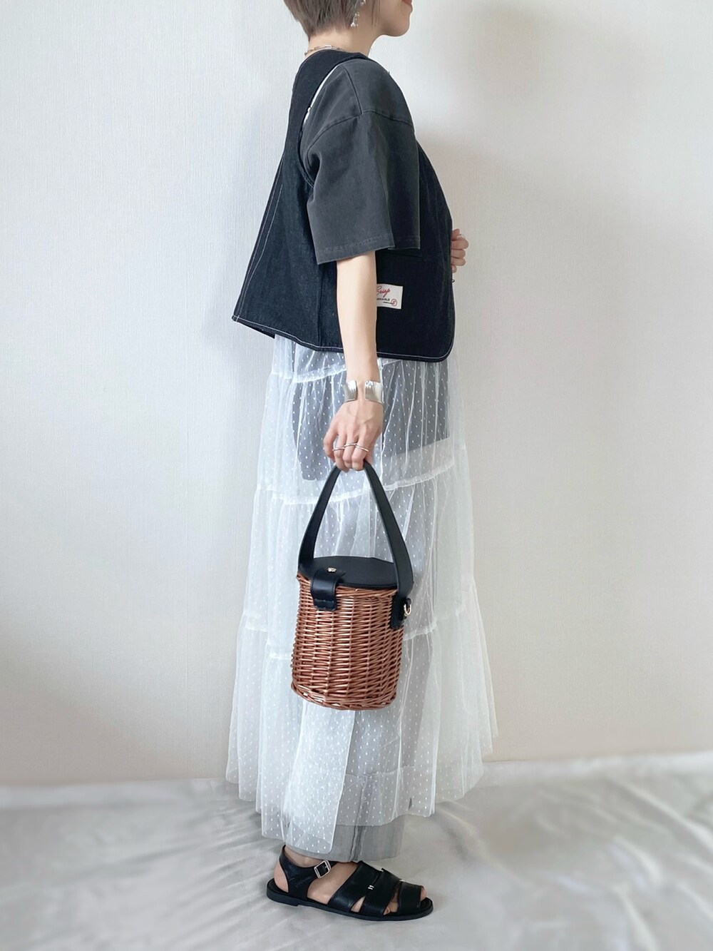 ブラック系のバッグ、ブラック系のサンダル、グレー系のデニムパンツを着用したレディースの夏コーディネートの3枚目の写真