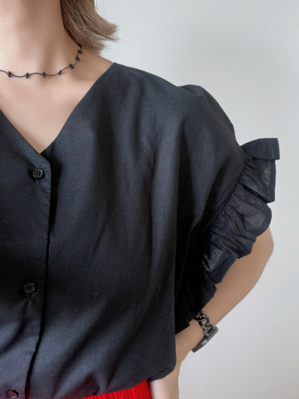 レッド系のスカート、ブラック系のシャツ/ブラウス、ブラック系のかごバッグを着用したレディースの秋コーディネートの5枚目の写真