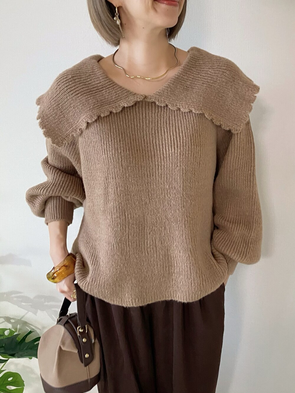 ブラウン系のその他パンツ、ブラウン系のローファー、ブラウン系のハンドバッグを着用したレディースの秋コーディネートの3枚目の写真