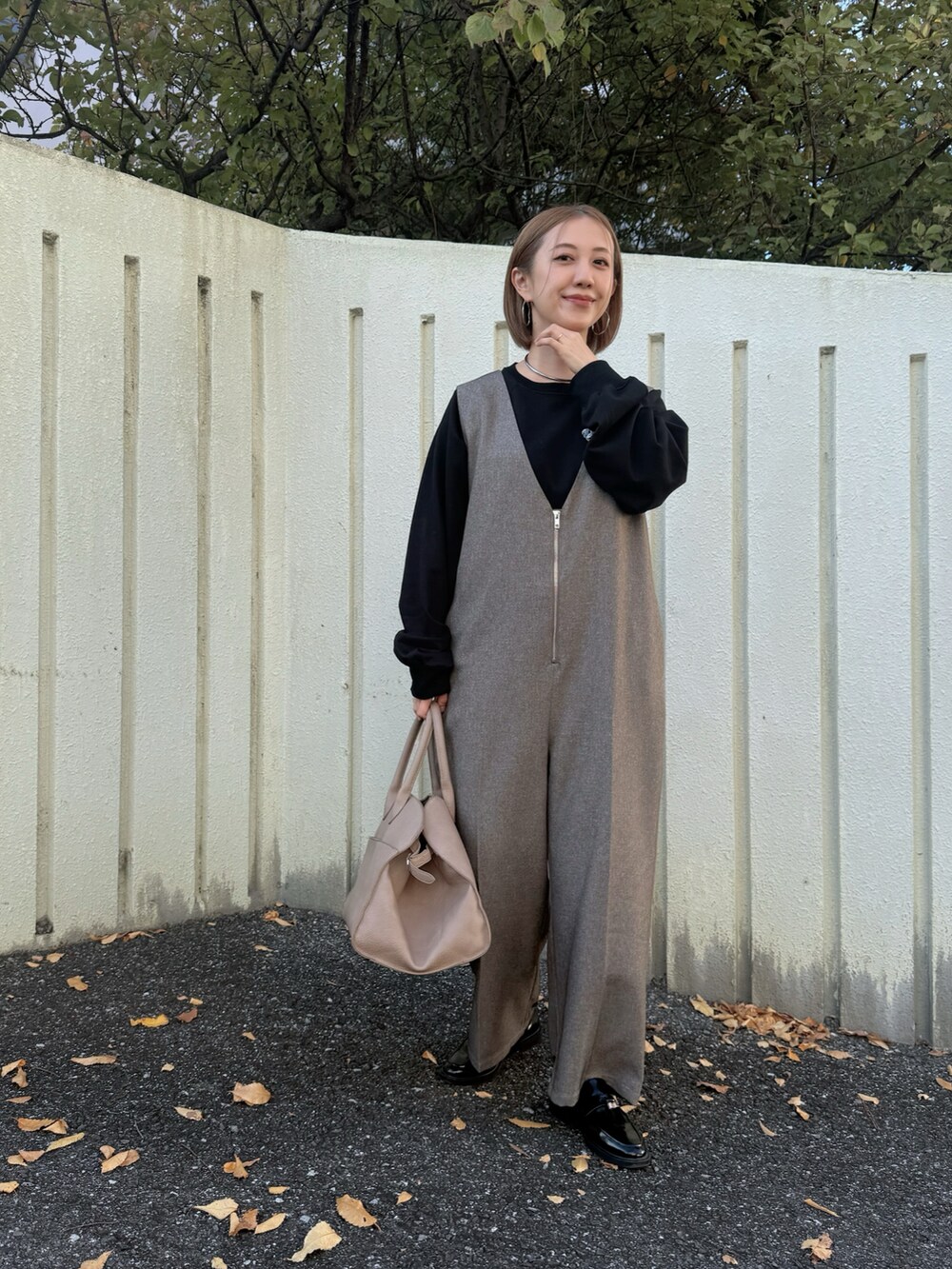 ベージュ系のボストンバッグ、ブラック系のローファー、ブラック系のスウェットを着用したレディースの冬コーディネートの2枚目の写真