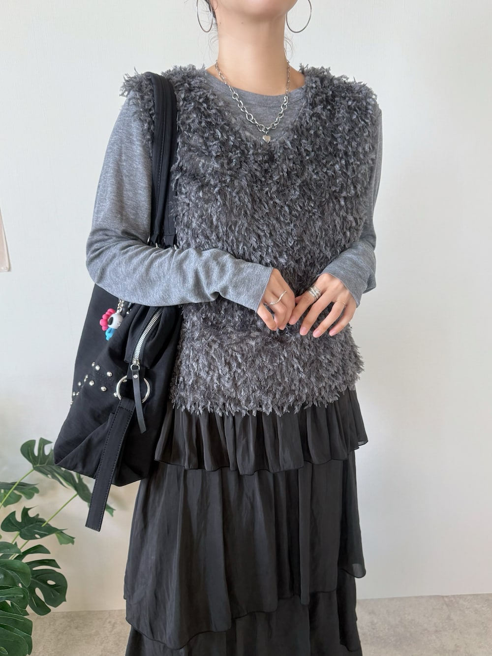 ブラック系のスカート、ブラック系のボストンバッグ、シルバー系のヘアピンを着用したレディースの秋コーディネートの4枚目の写真