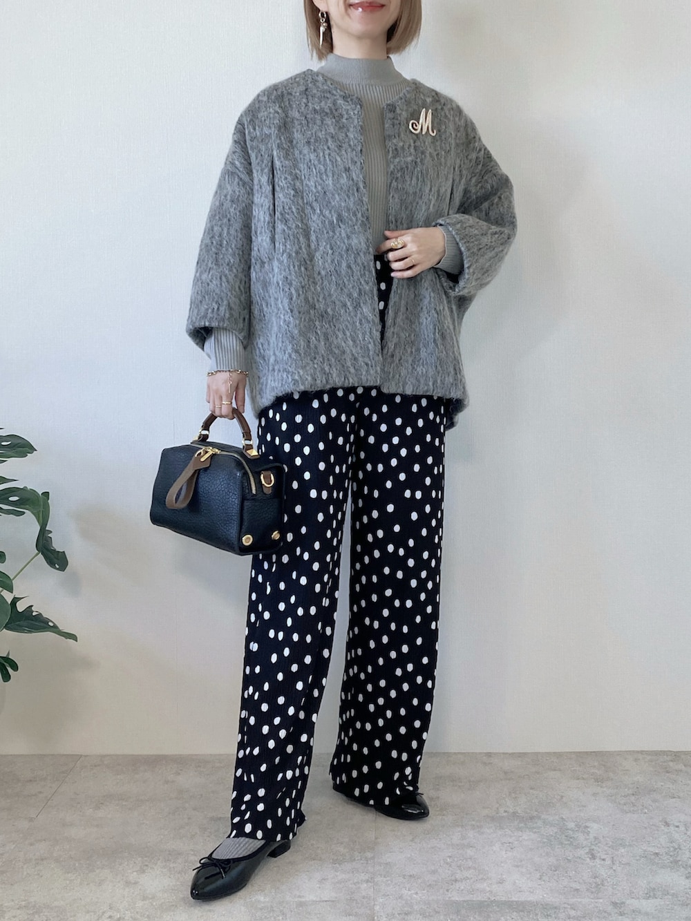 グレー系のダウンジャケット/コート、ブラック系のその他パンツ、ブラック系のパンプスを着用したレディースの冬コーディネートの4枚目の写真