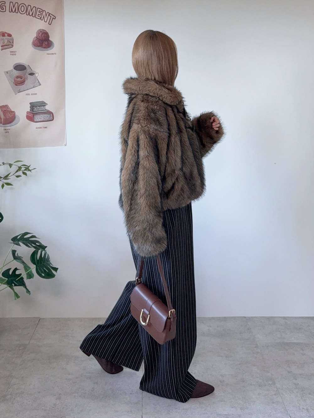 ブラウン系のブルゾン、ブラウン系のハンドバッグ、ブラック系のその他パンツを着用したレディースの冬コーディネートの3枚目の写真