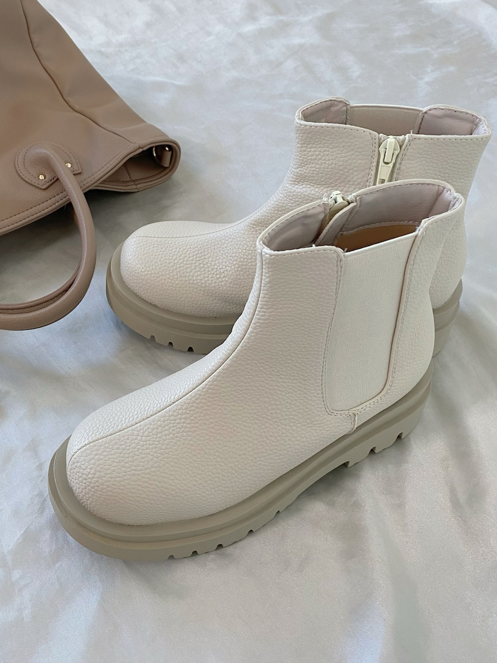 ベージュ系のバッグ、ブラウン系のワンピース、ホワイト系のブーツを着用したレディースの秋コーディネートの4枚目の写真