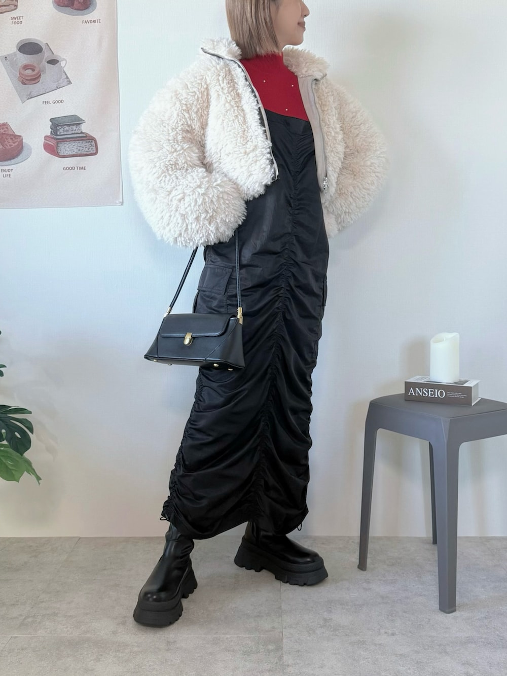 ブラック系のワンピース、ホワイト系のブルゾン、レッド系のニット/セーターを着用したレディースの冬コーディネートの3枚目の写真