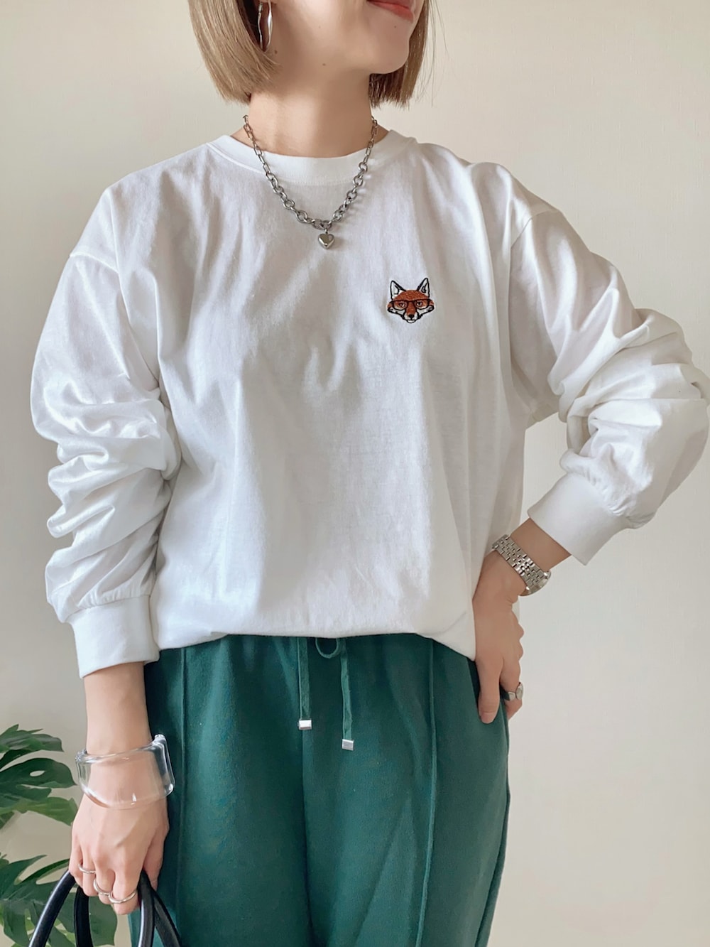 ホワイト系のTシャツ/カットソー、グリーン系のスウェットパンツ、ブラック系のバッグを着用したレディースの春コーディネートの2枚目の写真