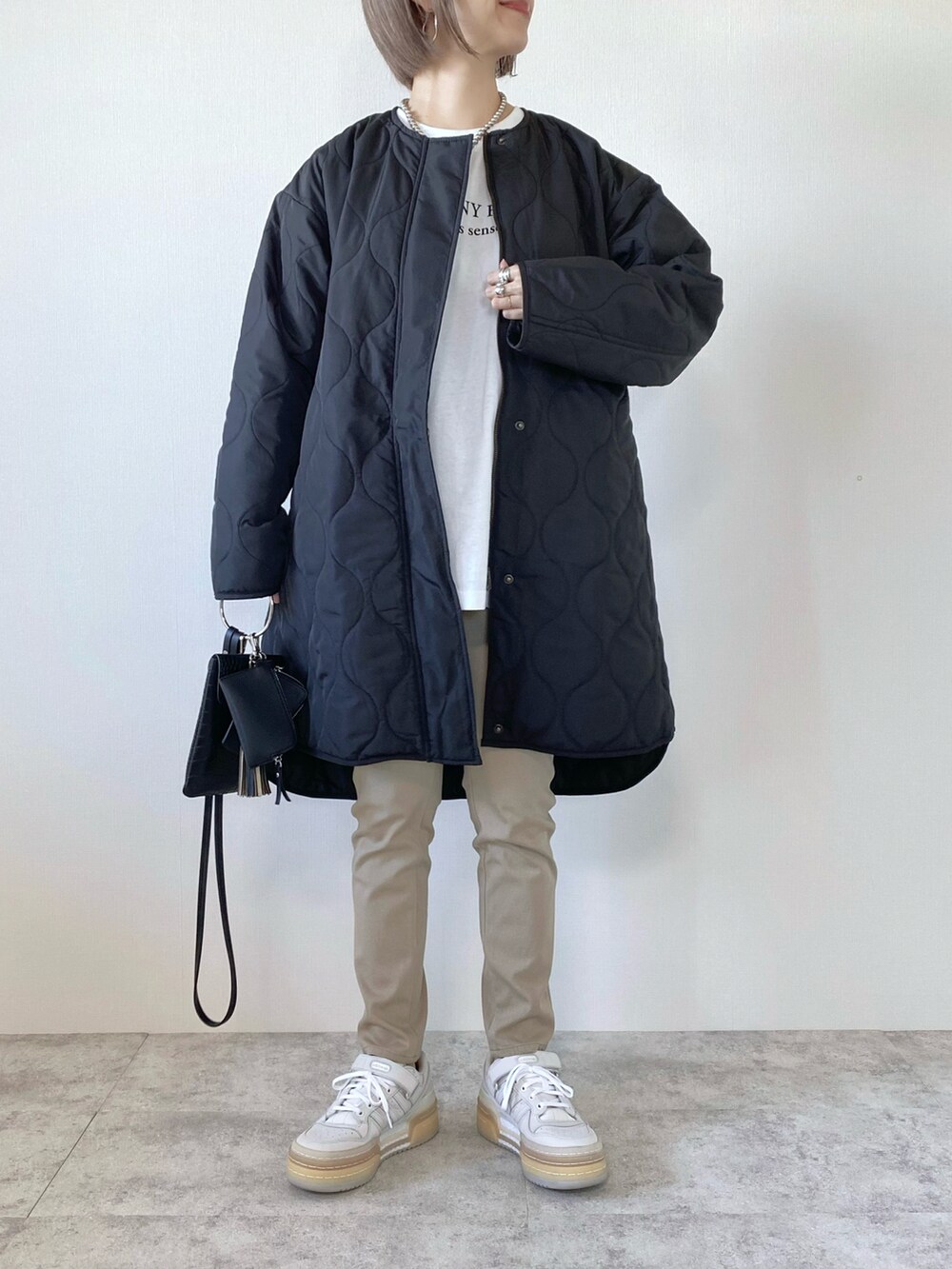 ホワイト系のスニーカー、ブラック系のショルダーバッグ、その他のTシャツ/カットソーを着用したレディースの秋コーディネートの3枚目の写真