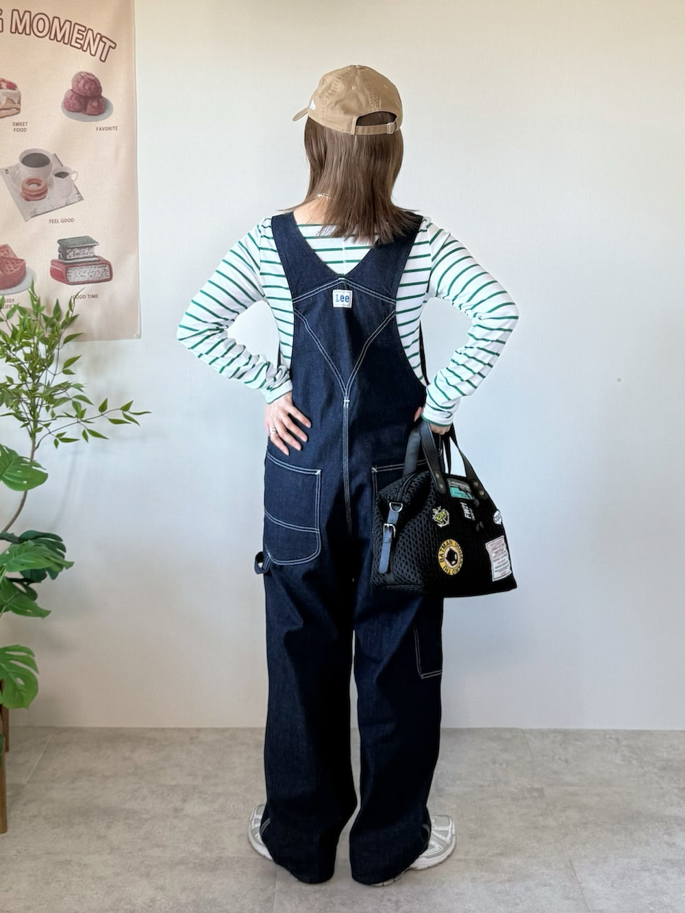 ホワイト系のスニーカー、ブラック系のボストンバッグ、グリーン系のTシャツ/カットソーを着用したレディースの冬コーディネートの4枚目の写真