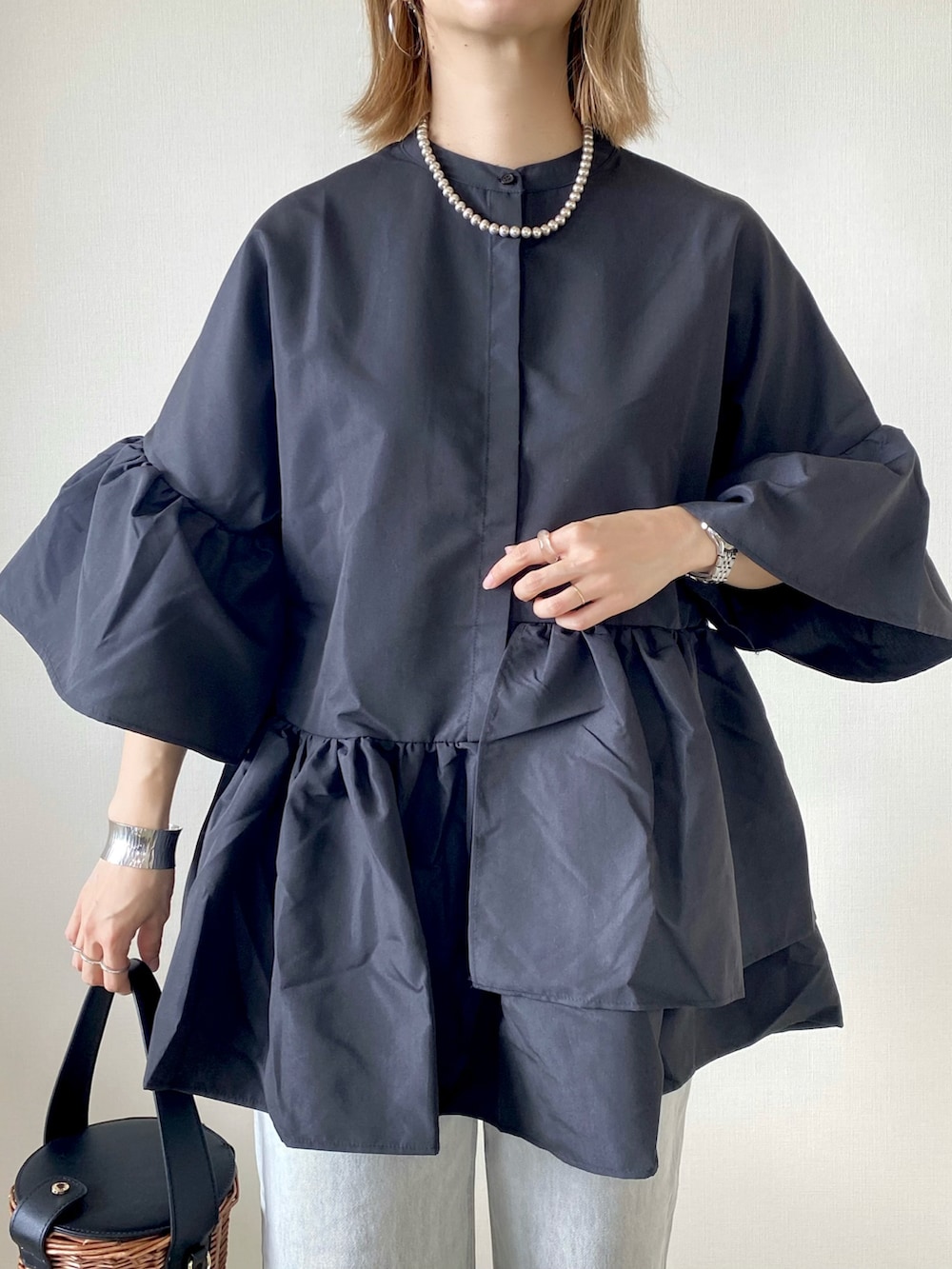 ブラック系のバッグ、シルバー系のサンダル、グレー系のデニムパンツを着用したレディースの夏コーディネートの2枚目の写真