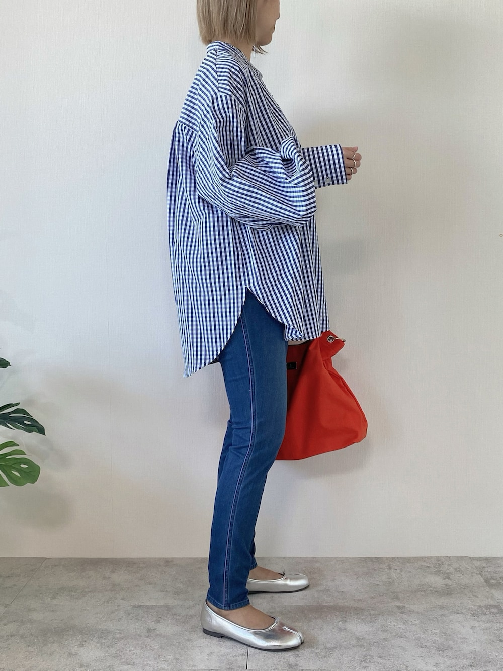 オレンジ系のトートバッグ、シルバー系のバレエシューズ、ブルー系のシャツ/ブラウスを着用したレディースの冬コーディネートの3枚目の写真