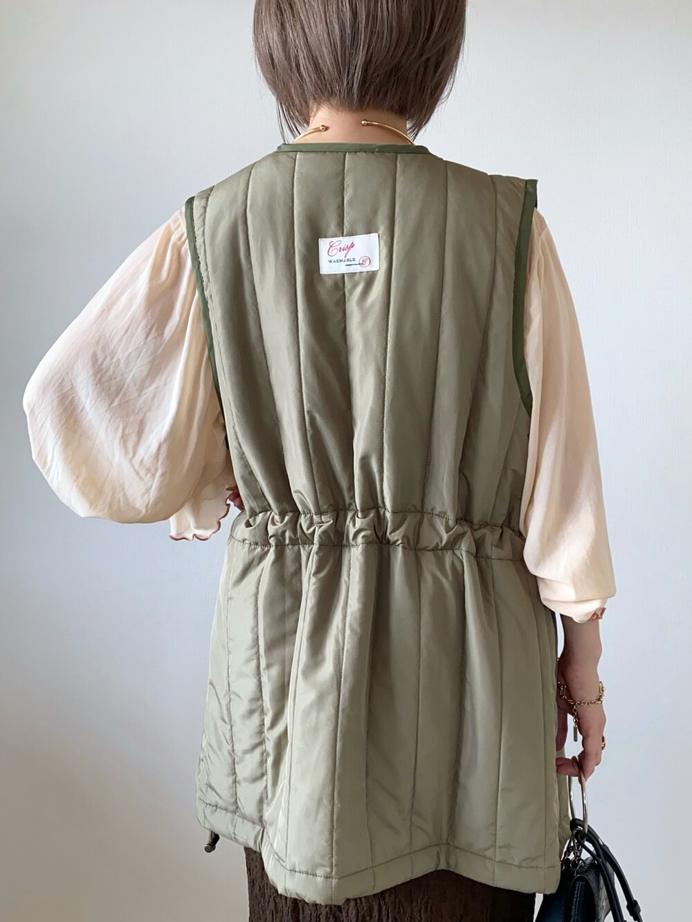 ベージュ系のTシャツ/カットソー、ブラウン系のスカート、ブラウン系のバレエシューズを着用したレディースの秋コーディネートの5枚目の写真