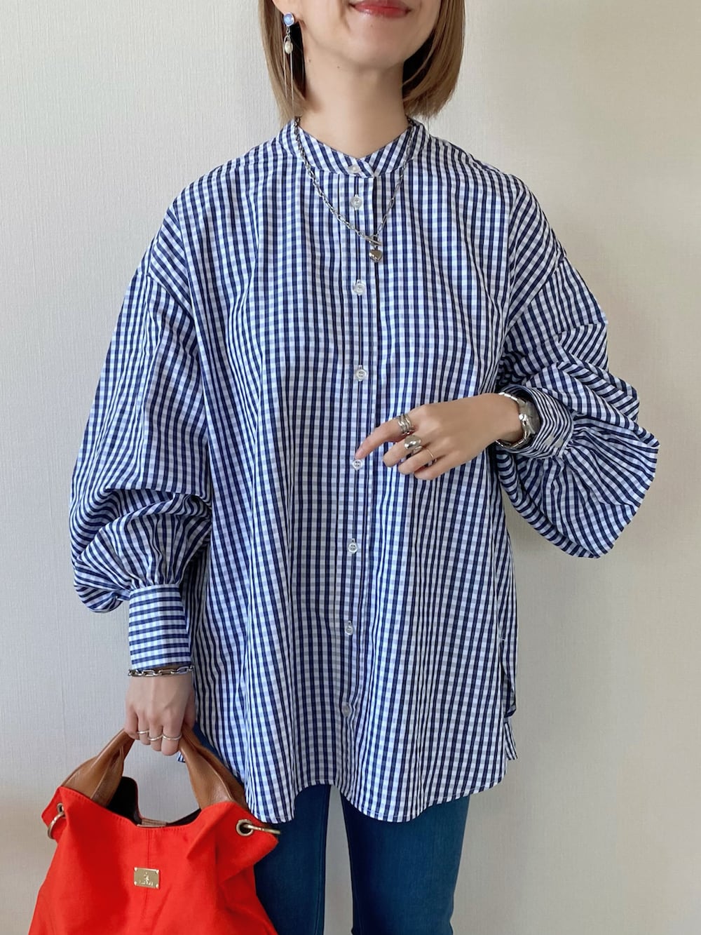 オレンジ系のトートバッグ、シルバー系のバレエシューズ、ブルー系のシャツ/ブラウスを着用したレディースの冬コーディネートの5枚目の写真