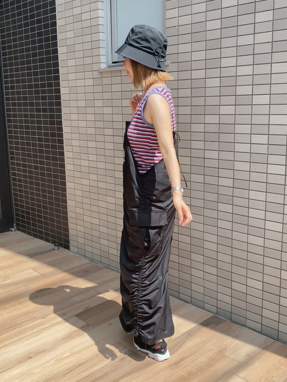 ブラック系のワンピース、ブラック系のボストンバッグ、ブラック系のスニーカーを着用したレディースの夏コーディネートの2枚目の写真