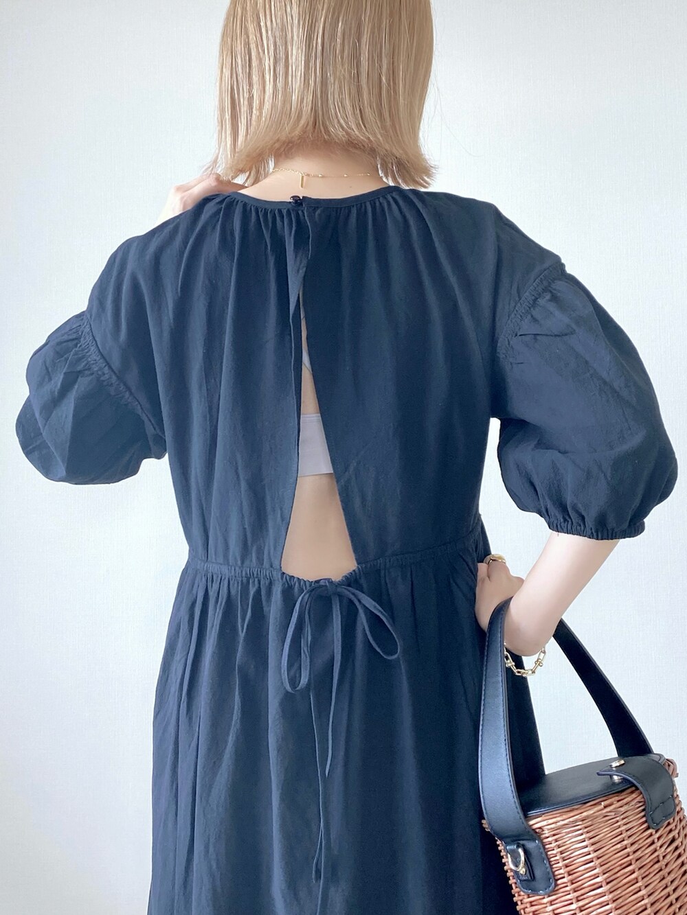 ブラック系のワンピース、ブラック系のバッグ、ホワイト系のサンダルを着用したレディースの春コーディネートの4枚目の写真