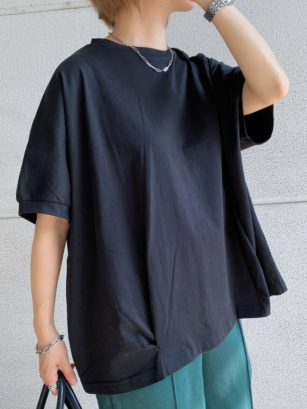 グリーン系のスウェットパンツ、ブラック系のTシャツ/カットソー、ブラック系のバッグを着用したレディースの夏コーディネートの5枚目の写真