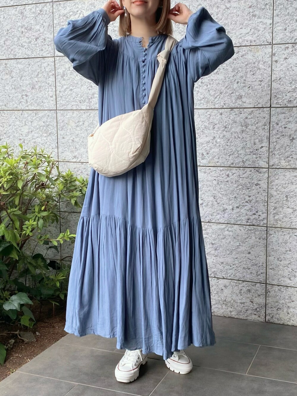 ホワイト系のショルダーバッグ、ブルー系のワンピース、ホワイト系のスニーカーを着用したレディースの春コーディネートの3枚目の写真