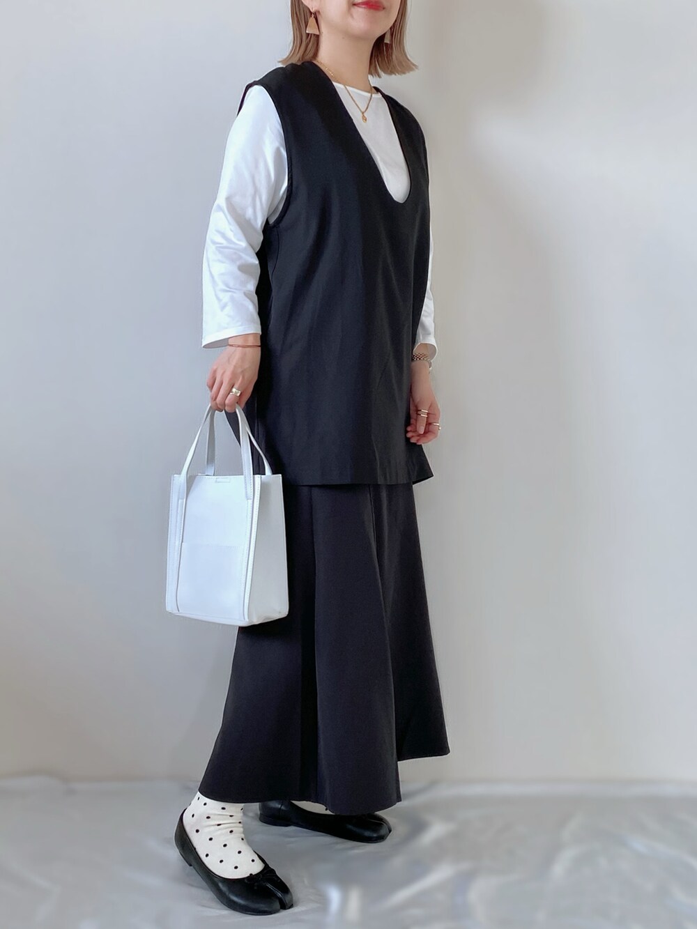 ブラック系のスカート、ブラック系のバレエシューズ、ブラック系のトップスを着用したレディースの春コーディネートの2枚目の写真