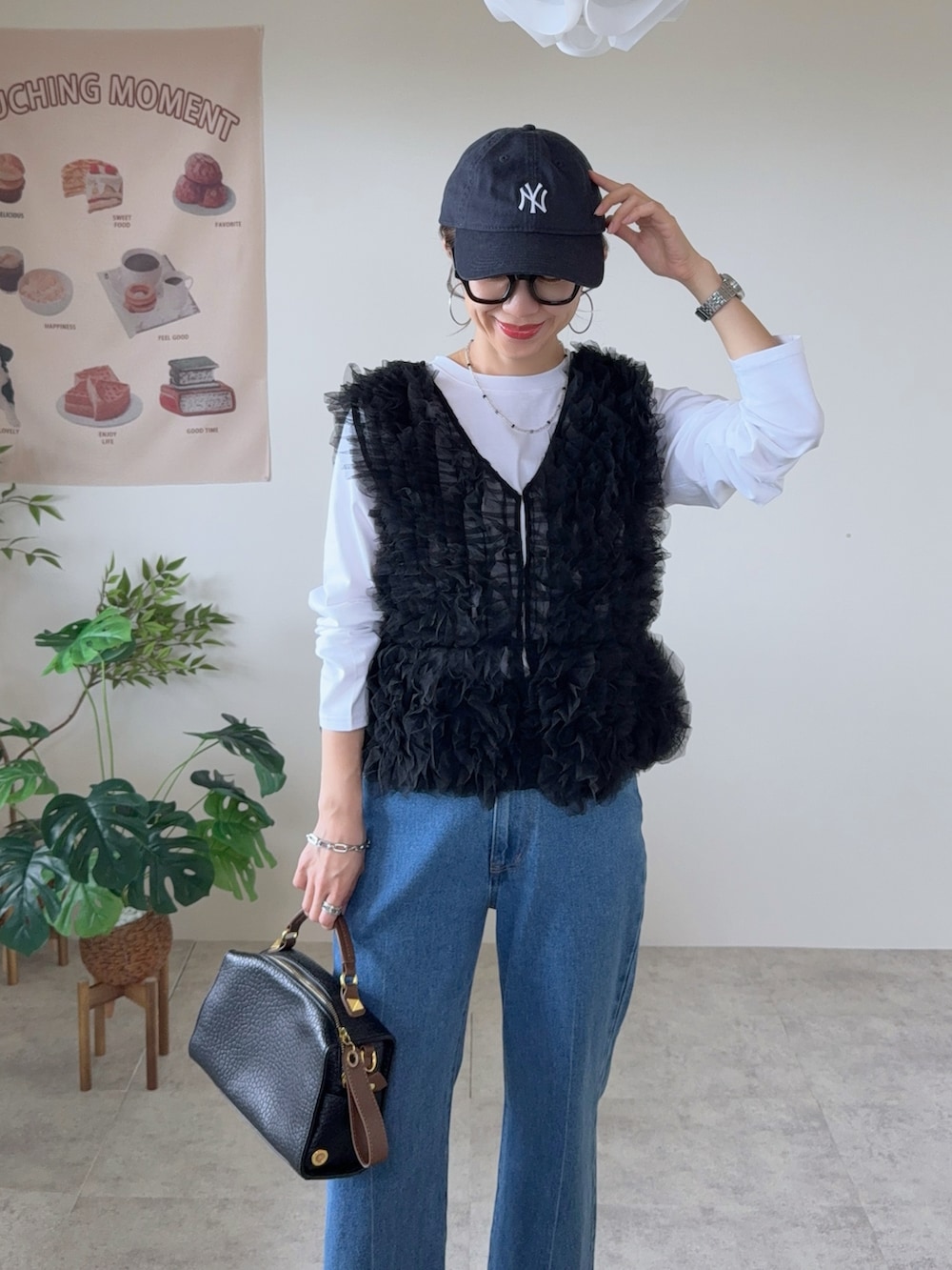ブラック系のベスト、ブルー系のデニムパンツ、レッド系のバレエシューズを着用したレディースの秋コーディネートの5枚目の写真