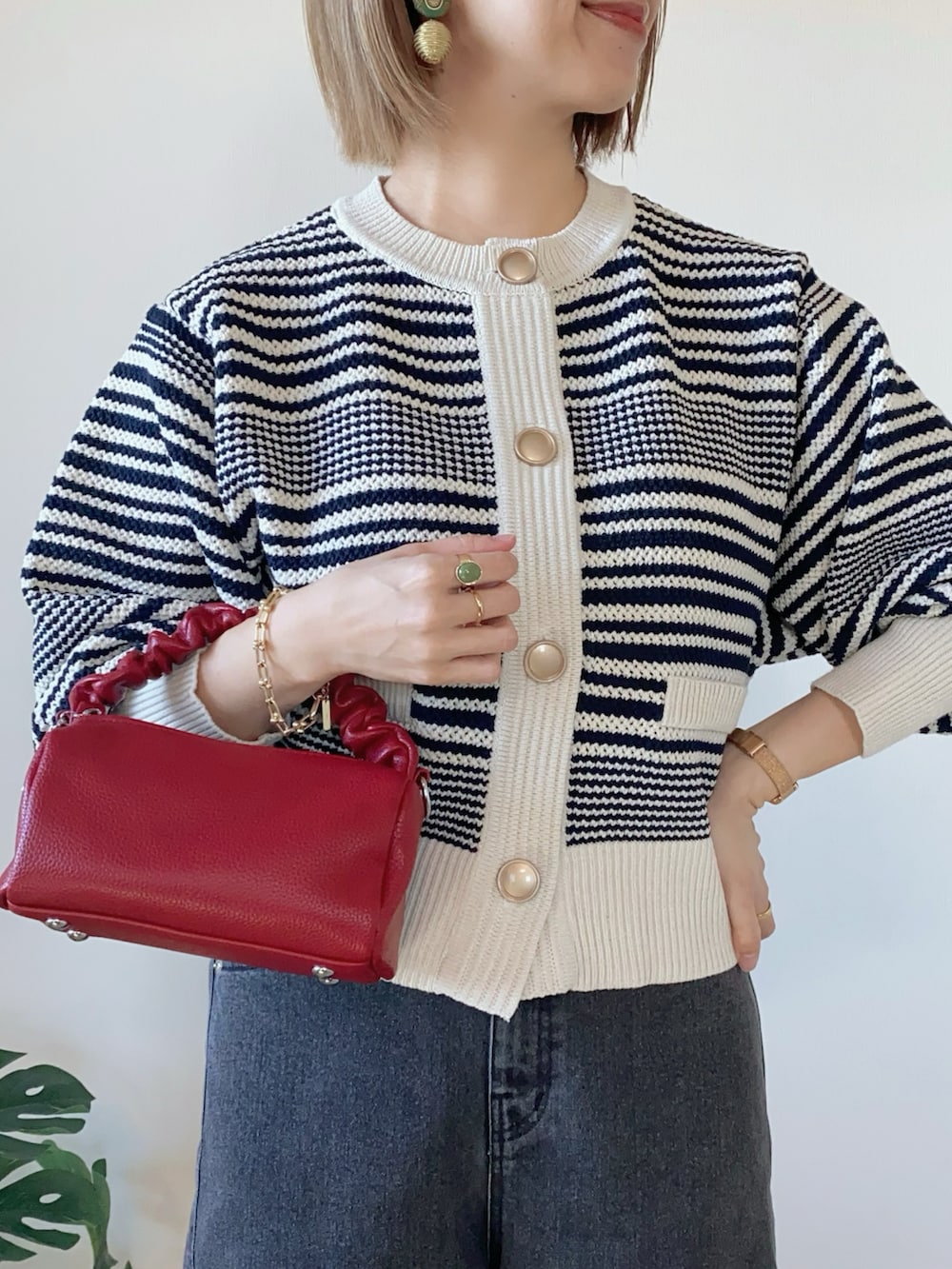 ブラック系のデニムパンツ、レッド系のボストンバッグ、シルバー系のバレエシューズを着用したレディースの冬コーディネートの3枚目の写真