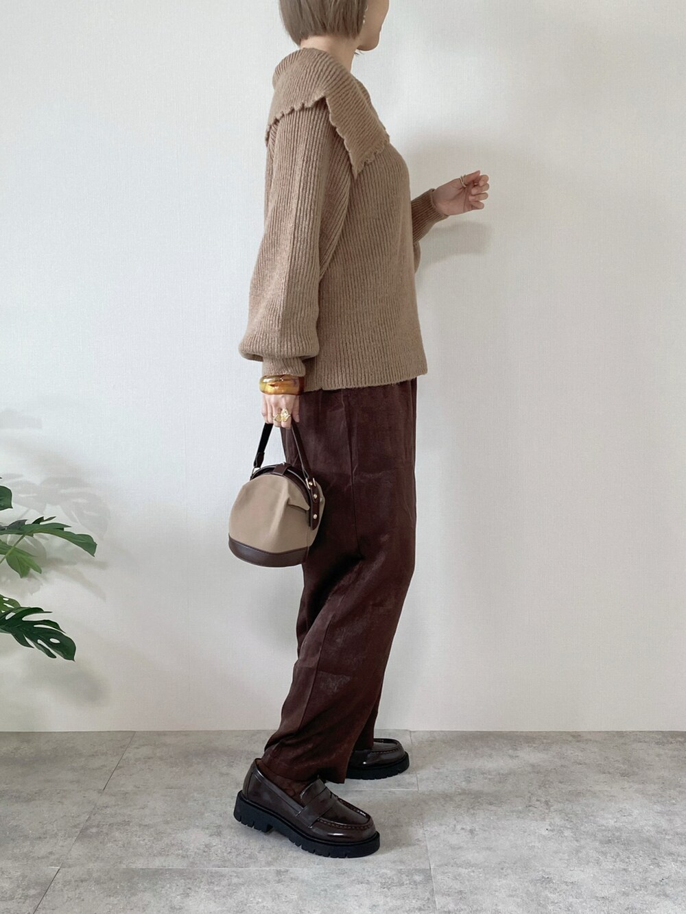 ブラウン系のその他パンツ、ブラウン系のローファー、ブラウン系のハンドバッグを着用したレディースの秋コーディネートの5枚目の写真