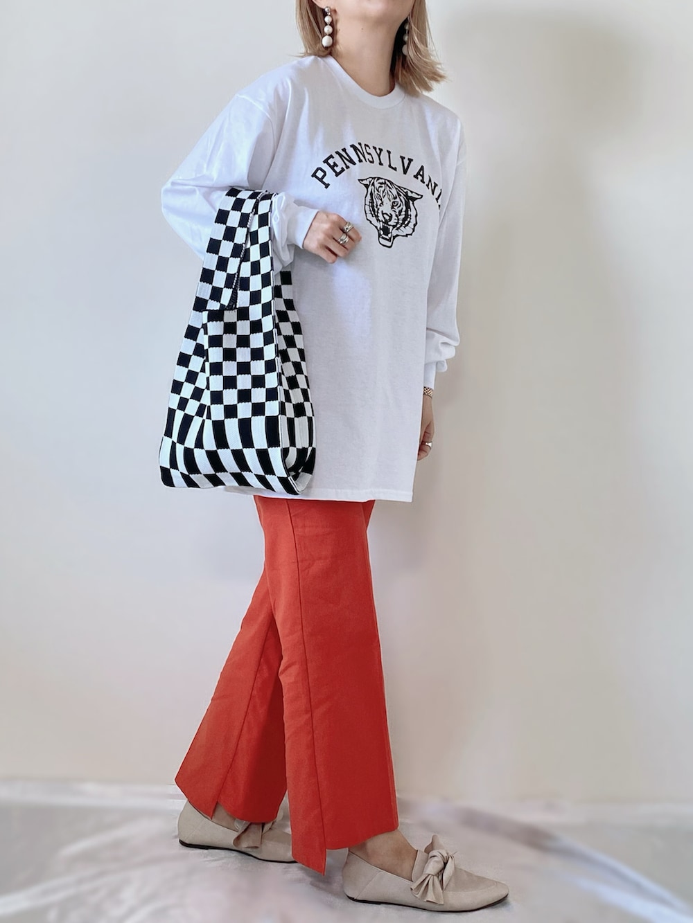 ホワイト系のTシャツ/カットソー、ブラック系のバッグ、オレンジ系のその他パンツを着用したレディースの春コーディネートの2枚目の写真